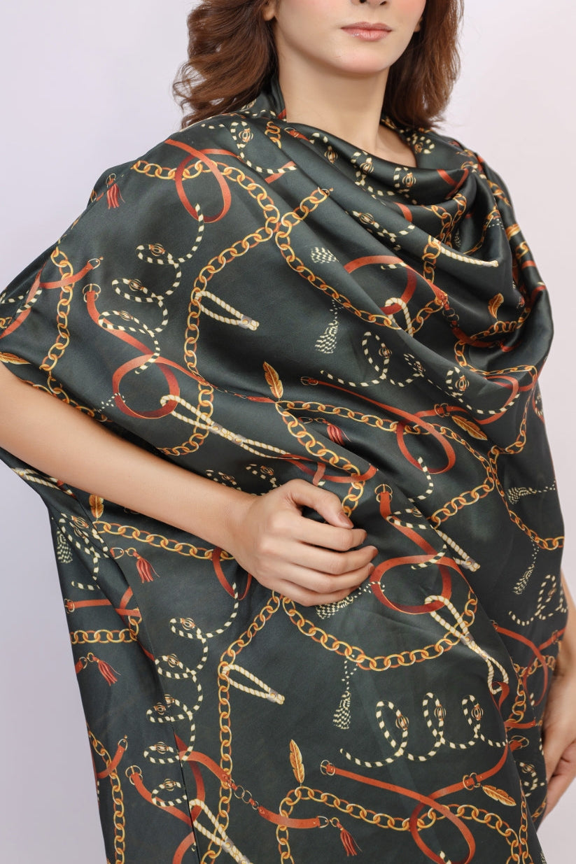 Woman wearing a dark green scarf with chain pattern on a plain background