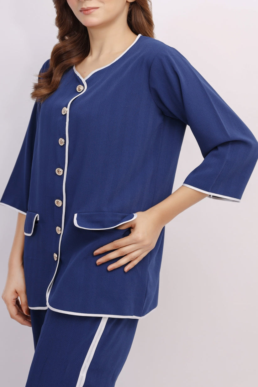 Woman wearing a blue pajama set with white buttons on a light gray background