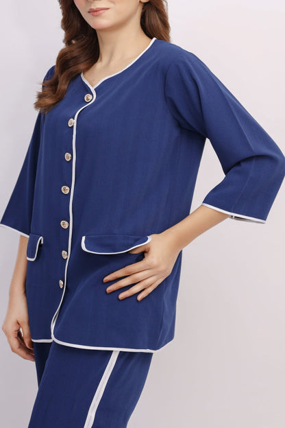 Woman wearing a blue pajama set with white buttons on a light gray background