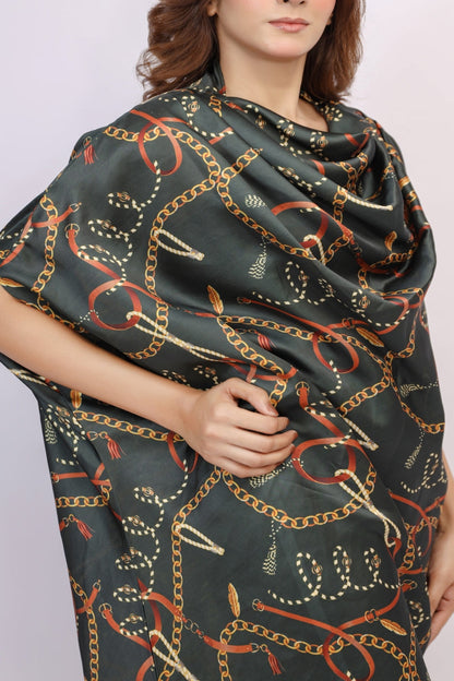 Woman wearing a dark green scarf with chain pattern on a plain background