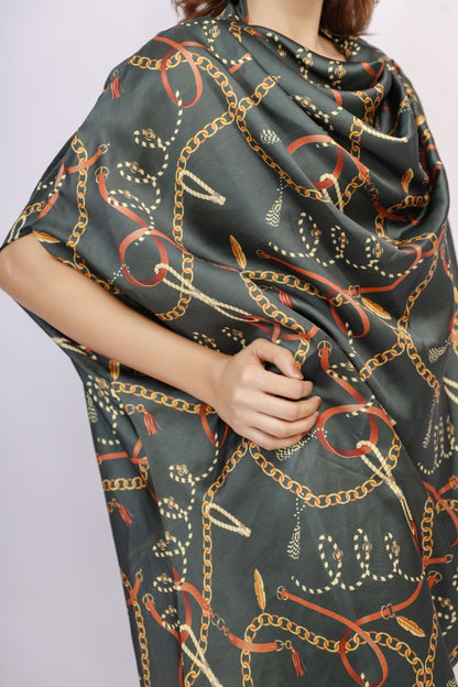 Person wearing a dark green scarf with chain pattern on a plain background