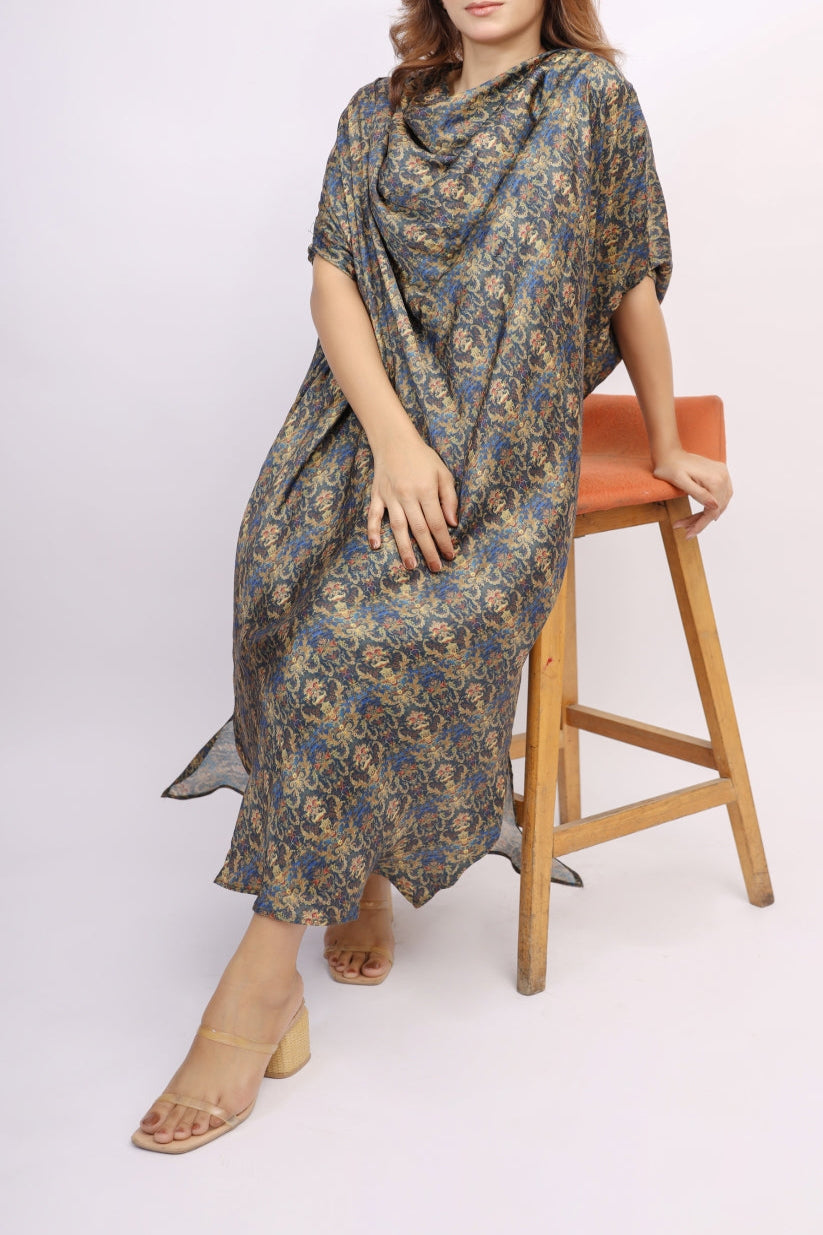 Woman wearing a floral dress sitting on a wooden stool against a white background