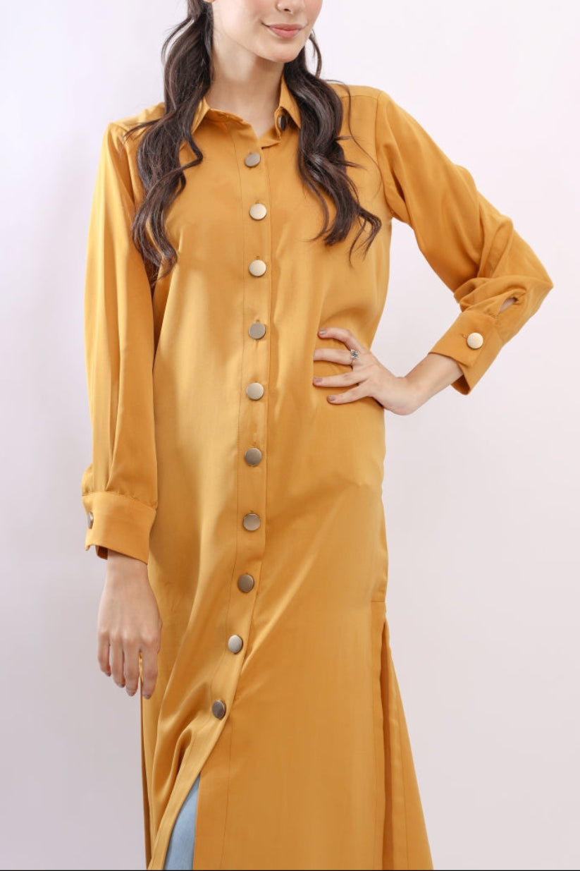 Woman wearing a mustard yellow dress with buttons on a white background