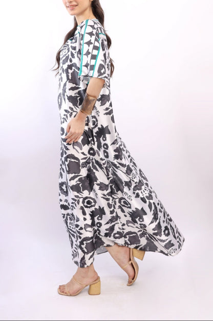 Woman wearing a long, patterned dress on a white background