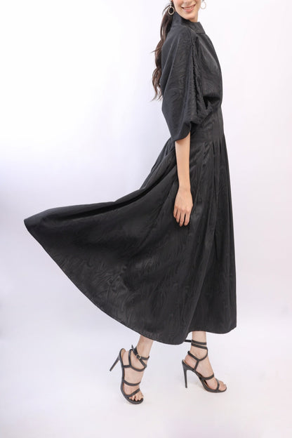 Woman wearing a black dress with a flowing skirt on a white background