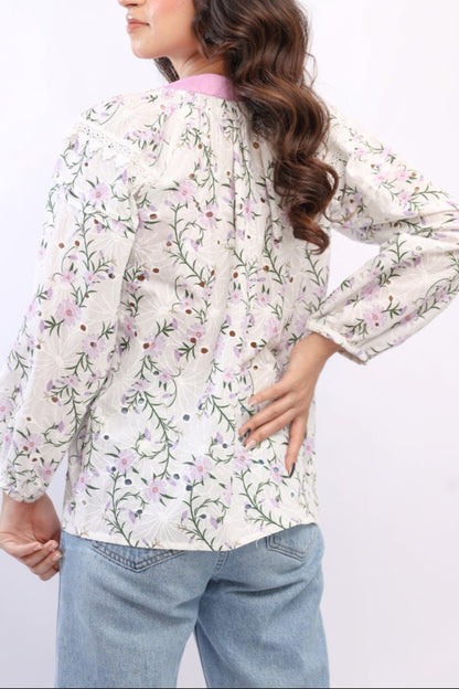 Woman wearing a floral blouse with long sleeves on a white background