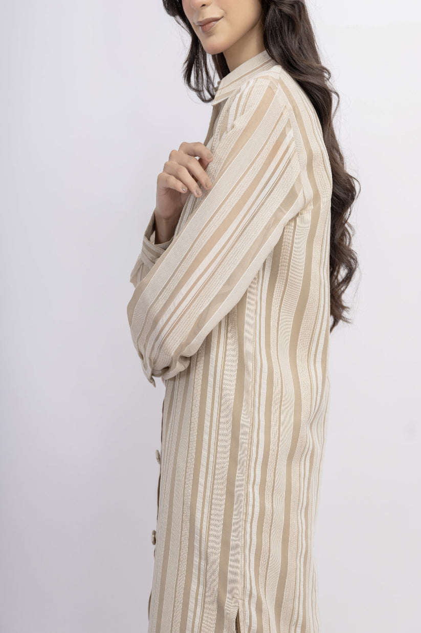 Woman wearing a beige and brown striped shirt against a white background